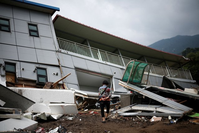 A woman inspects damage around a collapsed building in the aftermath of torrential rain, in Gapyeong, South Korea on July 21, 2025. (Photo by Kim Hong-Ji/Reuters)