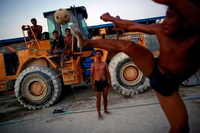 Workers play "chinlone" after work at a construction site in Yangon, Myanmar on  October 22, 2015. (Photo by Soe Zeya Tun/Reuters)