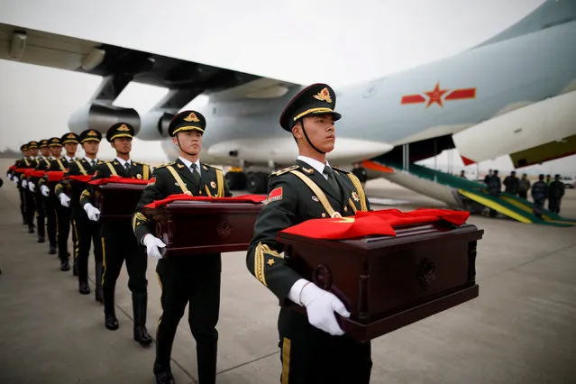 Chinese soldiers carry caskets containing the remains of Chinese soldiers covered by Chinese national flags during the handing over ceremony at the Incheon International Airport in Incheon, South Korea, March 28, 2018. (Photo by Kim Hong-Ji/Reuters)