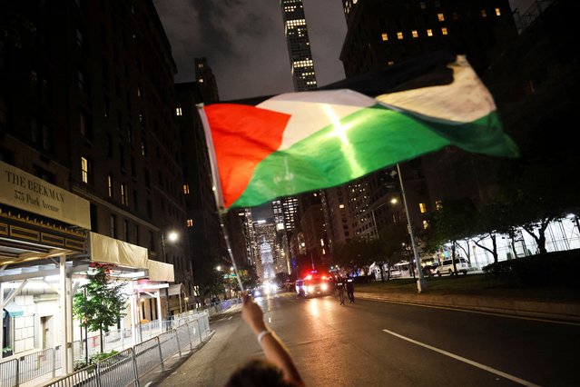 A person waves a Palestinian flag during a protest against Israeli Prime Minister Benjamin Netanyahu prior to his arrival to a hotel in Manhattan, ahead of his address to the 80th United Nations General Assembly (UNGA) at the U.N. headquarters, in New York, U.S., September 25, 2025. (Photo by Carlos Barria/Reuters)
