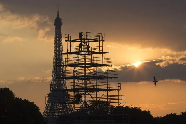 Workers are seen in silhouette, along with the Eiffel Tower, as they construct scaffolding on the Place de la Concorde as the sun sets on an autumn day in Paris, France, October 13, 2015. (Photo by Philippe Wojazer/Reuters)