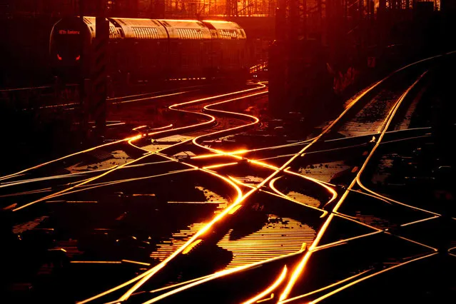 A train is parked outside a train station in Frankfurt, Germany as the sun sets on Monday, January 23, 2023. (Photo by Michael Probst/AP Photo)