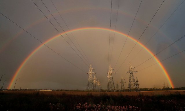 A rainbow is seen behind electrical pylons in a field near the town of Zhodino, Belarus, July 23, 2020. (Photo by Vasily Fedosenko/Reuters)
