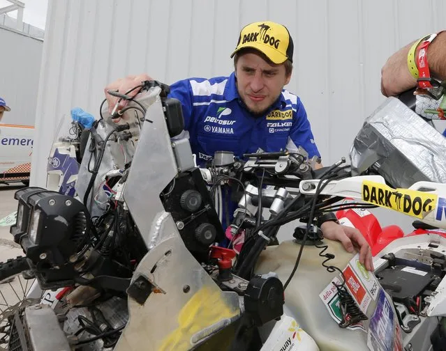 Paraguay's Nelson Sanabria checks his Yamaha quad while waiting for technical verification ahead of the Dakar Rally 2015 in Buenos Aires January 1, 2015. (Photo by Enrique Marcarian/Reuters)