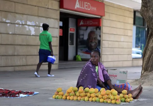A Zimbabwean fruit vendor waits for customers in front of a closed branch of Allied bank in central Harare January 9, 2015. Allied, one of Zimbabwe's smaller banks owned by a senior minister in President Robert Mugabe's government, has surrendered its licence because it was insolvent and had a high level of non-performing loans, two sources at the bank said on Thursday. (Photo by Philimon Bulawayo/Reuters)