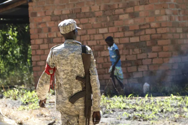 A soldier walks through a market outside of Yei town in Central Equatoria state, Wednesday, December 23, 2020. Ten years after South Sudan gained its independence and two years after its own deadly civil war ended, large-scale fighting has subsided but clashes continue between communities and between the government and groups that did not sign the peace deal — and the use of rape as a weapon remains rampant. (Photo by Sam Mednick/AP Photo)