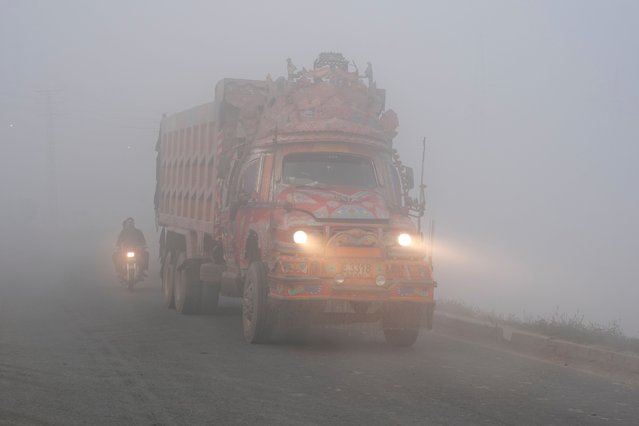 A truck moves with lights on due to smog enveloping the area of Lahore, Pakistan, Friday, October 31, 2025. (Photo by K.M. Chaudary/AP Photo)