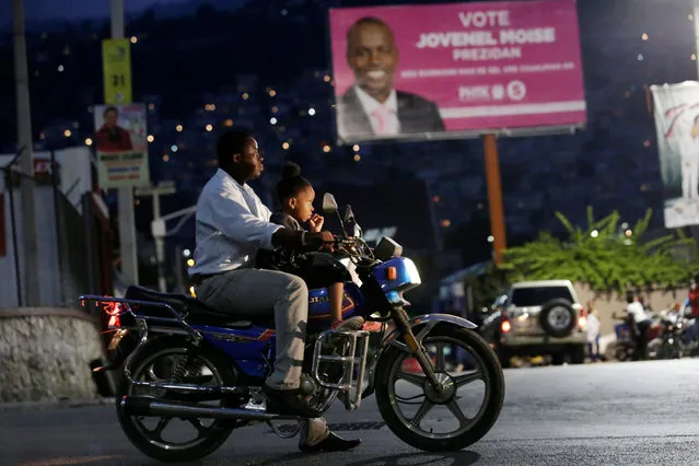 A man and a girl ride a motorbike next to a billboard advertising presidential candidate Jovenel Moise of the PHTK party, in Port-au-Prince, Haiti, November 6, 2016. (Photo by Andres Martinez Casares/Reuters)
