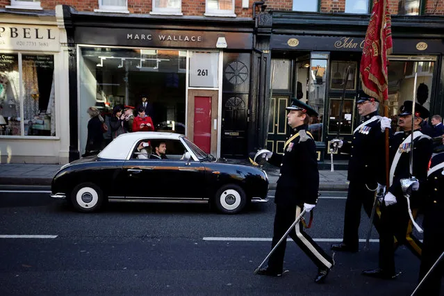 A man driving a car watches a Remembrance Sunday parade through Fulham in West London, Britain November 11, 2012. (Photo by Kevin Coombs/Reuters)