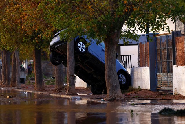 A car leans precariously against a wall after severe flooding in Utiel, Spain, on October 30, 2024. (Photo by Susana Vera/Reuters)