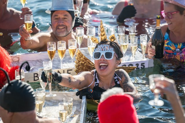 Revellers take part in a New Year's day swim in Lake Geneva with its 7.3 degree celsius waters in Geneva on January 1, 2025. (Photo by Fabrice Coffrini/AFP Photo)