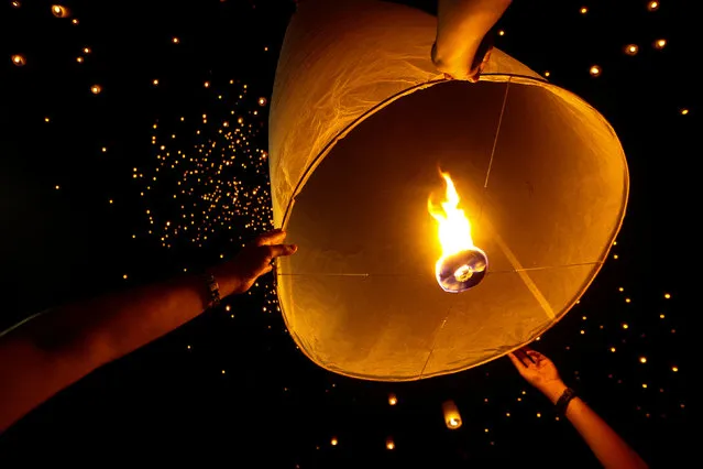 People hold up floating lanterns before they release during the festival of Yee Peng in the northern capital of Chiang Mai, Thailand November 14, 2016. (Photo by Athit Perawongmetha/Reuters)
