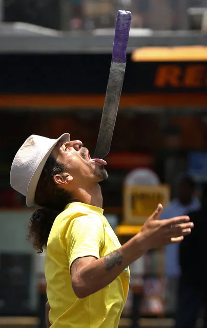 Street artist Ruben Acosta balances a knife on his tongue as he performs for tips in Lima, Peru, Monday, January 26, 2015. Acosta is known for juggling three machetes at a time as he stands between cars waiting at stoplights. (Photo by Martin Mejia/AP Photo)