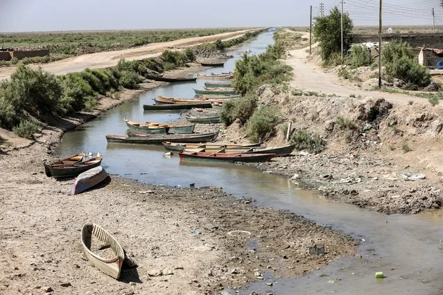 Fishermen's boats lie close to the drying riverbed of the Amshan river, which is fed by the Tigris, in al-Majar al-Kabir in Iraq's southeastern Maysan governorate on July 3, 2023. (Photo by Asaad Niazi/AFP Photo)