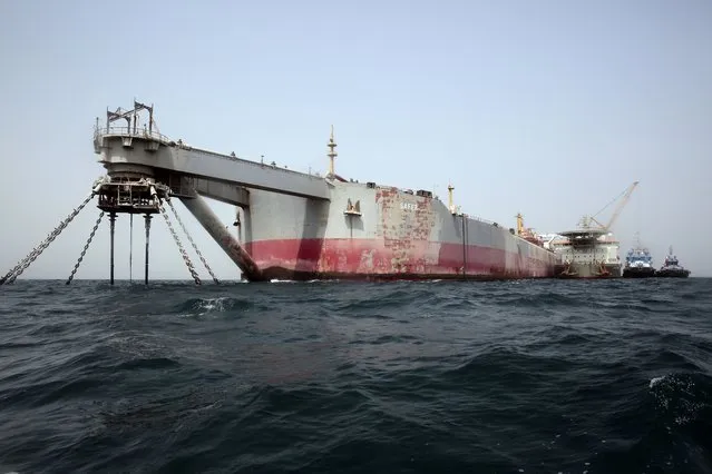 Technical vessels are seen by the decrepit Safer tanker on Monday, June 12, 2023, off the coast of Yemen. Safer has posed an environmental threat since 2015, as it decayed and threatened to spill its contents of 1.14 million barrels into the Red Sea and Indian Ocean. In May, the United Nations announced that the first step of the ship's salvage process had begun, with the arrival of a ship that would remove atmospheric oxygen from the ship's oil chambers. (Photo by Osamah Abdulrahman/AP Photo)