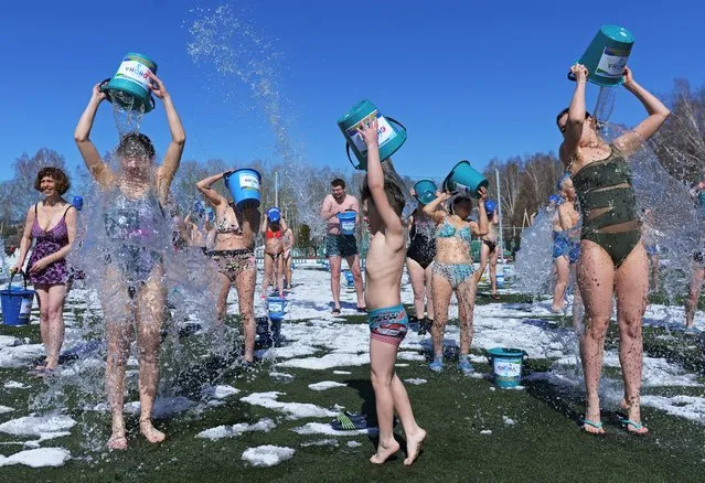 People dump buckets of ice water on themselves during the annual spring event “Awakening” in the Siberian city of Tomsk, Russia on April 17, 2021. (Photo by Taisiya Vorontsova/Reuters)