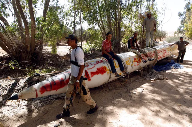 Anti-Gaddafi fighters sit on a Soviet-made SCUD missile outside a village near Sirte, Libya one of Muammar Gaddafi's last remaining strongholds September 21, 2011. (Photo by Goran Tomasevic/Reuters)