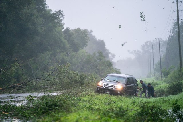 People work to free a vehicle stuck on the shoulder amid storm debris as Hurricane Idalia crosses the state on August 30, 2023 near Mayo, Florida. The storm made landfall at Keaton Beach, Florida as Category 3 hurricane. (Photo by Sean Rayford/Getty Images)