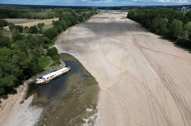 A view shows a barge moored along the banks of a branch of the Loire River in Loireauxence, France on July 26, 2023. (Photo by Stephane Mahe/Reuters)