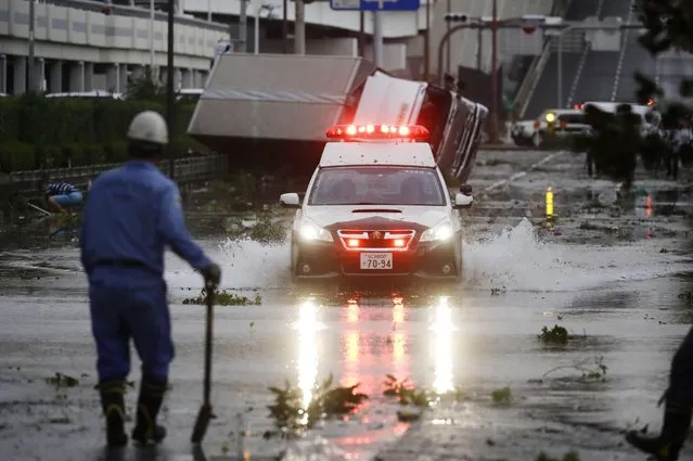A police car makes through a flooded road following a powerful typhoon in Osaka, western Japan, Tuesday, September 4, 2018. (Photo by Kota Endo/Kyodo News via AP Photo)