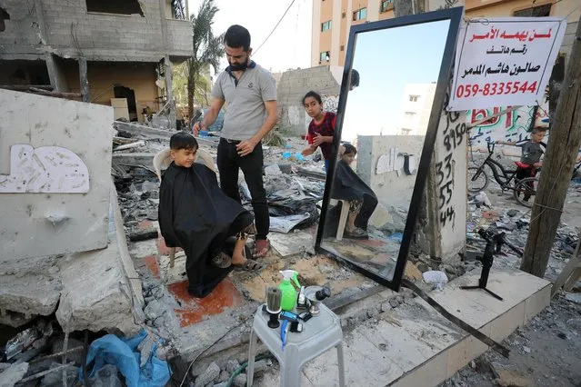 A barber works amid rubble of his shop, which was destroyed in an Israeli airstrike during Israeli-Palestinian fighting, in Gaza City on May 25, 2021. (Photo by Mohammed Salem/Reuters)