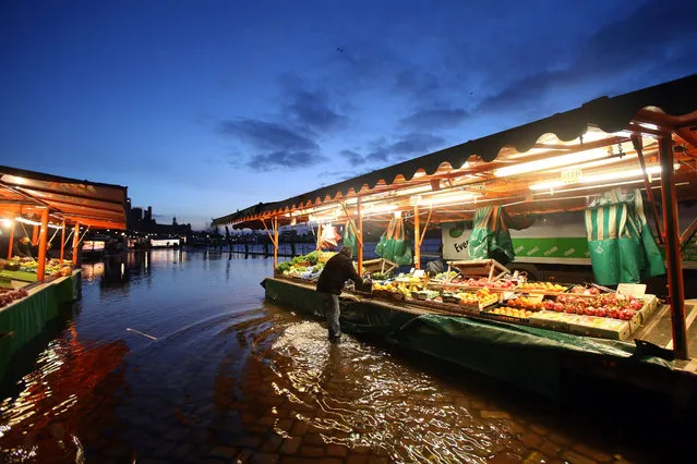 A vendor arranges produce at this market stand at the Fish Market in the city of Hamburg, Germany, 31 January 2016. A storm flood caused flooding to the famous trading area in the city of Hamburg in the morning. (Photo by Bodo MarksEPA)