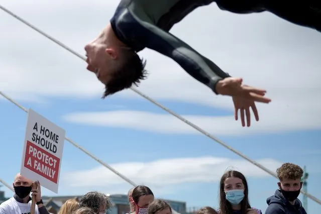 A man jumps into the River Liffey during a demonstration to demand redress for the usage of porous mica blocks in housing, in Dublin, Ireland on June 15, 2021. (Photo by Clodagh Kilcoyne/Reuters)