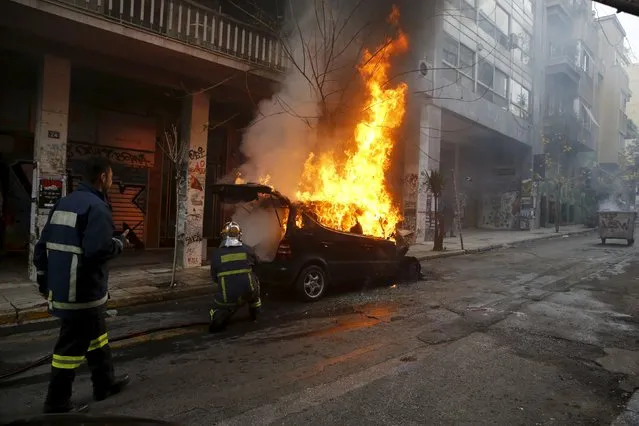 A fireman tries to extinguish a burning car set ablaze by masked protesters during clashes following protests in a 24-hour general strike by worker's unions against planned pension reforms in central Athens, Greece, February 4, 2016. (Photo by Yannis Behrakis/Reuters)
