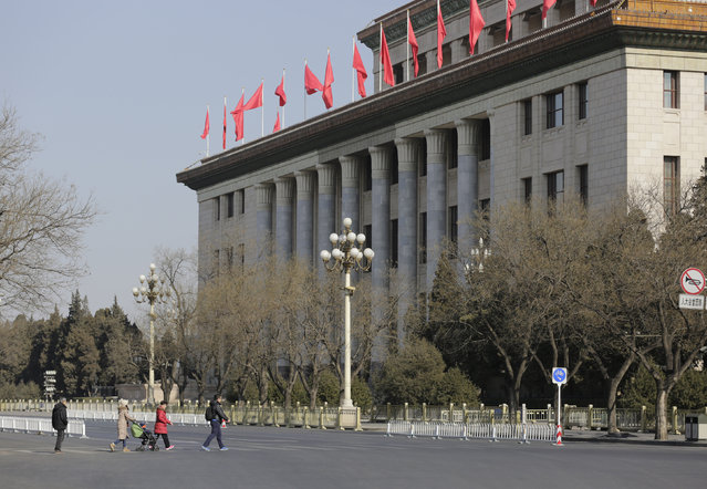 A tourist family walks on a crosswalk in front of the Great Hall of the People on the eve of Chinese Lunar New Year in Beijing, China, February 7, 2016. (Photo by Jason Lee/Reuters)