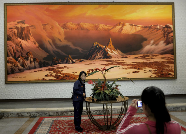 In this Tuesday, October 23, 2018, photo, a woman has her photo taken in front of a painting of the sacred Mount Paektu, in the lobby of the Kumgangsan Hotel at the Mount Kumgang resort area in North Korea. (Photo by Dita Alangkara/AP Photo)
