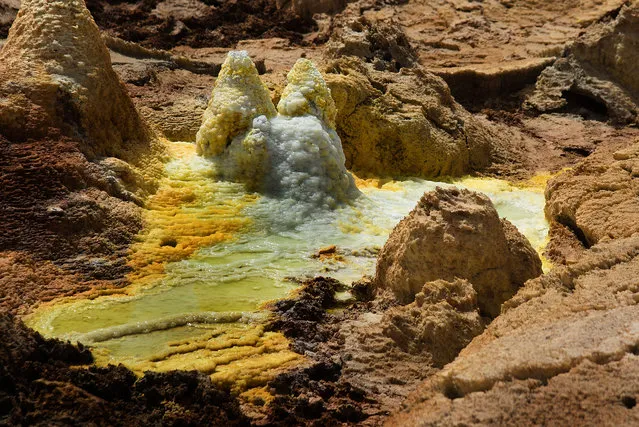 Thanks to plenty of salt minerals and heavy elements in the soil, the Dallol volcano in Ethiopia produces brilliantly colored pools of water at the top of its caldera. And, as if to add greater effect to the already stunning sights, the volcano stands apart from the salt plains around it like an island. This hotspot was created through phreatomagmatic eruptions caused by magma interacting with water, and was further altered due to the presence of salt water. (Photo by Francisco Pandolfo/Caters News)