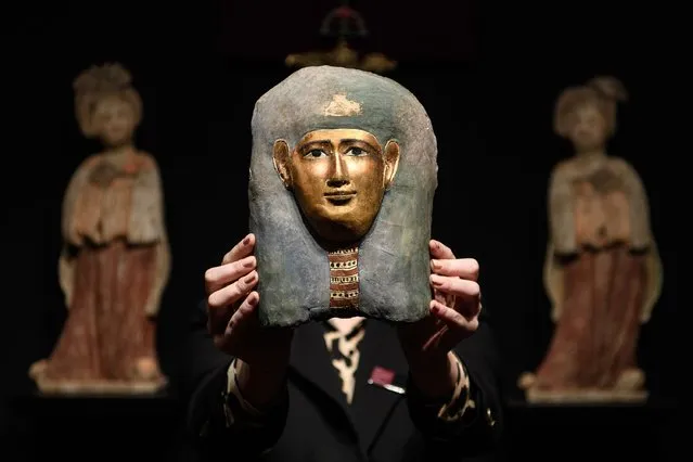 An Egyptian child's mummy mask from 305-30BC is held up at the Mayfair Antiques and Fine Art Fair on January 5, 2017 in London, England. Running from January 5 to Sunday 8, the fair sees over forty exhibitors with pieces ranging from 1300BC to the present day available for sale. (Photo by Leon Neal/Getty Images)