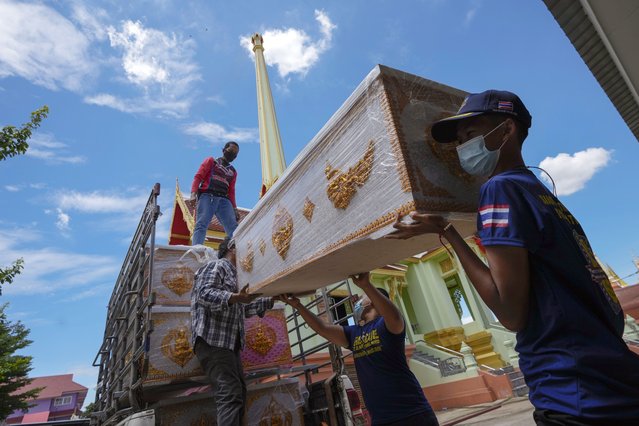 People donate an empty coffin for the Wat Ratprakongtham temple Nonthaburi Province, Thailand, Monday, July 12, 2021. Wat Ratprakongtham temple offering free funeral service for people dying from COVID-19 says it is struggling to keep up with 24-hour cremation, and is adding another crematorium as Thailand sees a growing number of cases and deaths in a coronavirus surge that began in early April. (Photo by Sakchai Lalit/AP Photo)