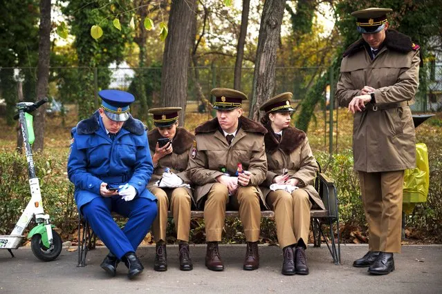 Military cadets sit on a bench before taking part in the National Day parade in Bucharest, Romania, Friday, December 1, 2023. Tens of thousands of people turned out in Romania's capital on Friday to watch a military parade that included troops from NATO allies to mark the country's National Day. (Photo by Vadim Ghirda/AP Photo)