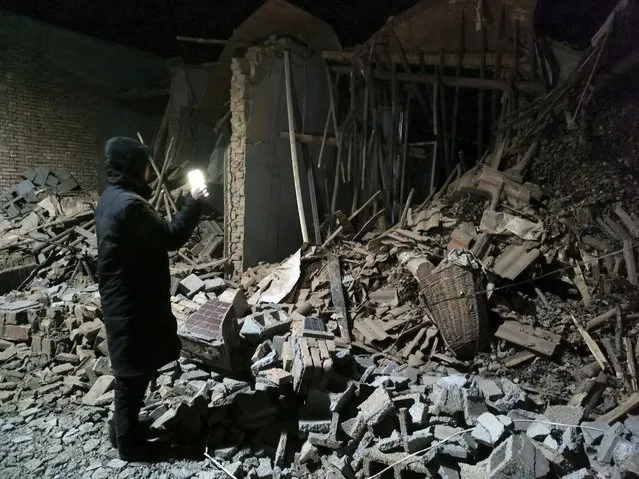 A government worker looks at the debris of a house brought down in the earthquake in Jishishan county in northwest China's Gansu province Tuesday, December 19, 2023. (Photo by Chinatopix via AP Photo)