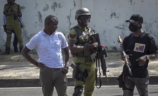 In this image made from video, security forces gather near a body in the street near the French embassy in Dar es Salaam, Tanzania Wednesday, August 25, 2021. (Photo by AP Photo/Stringer)