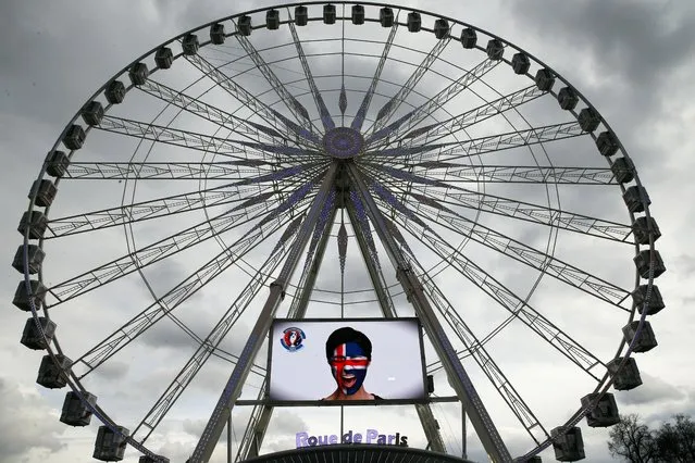 Pictures of soccer fans are displayed on the ferris wheel as part of the upcoming Euro 2016 tournament, in Paris, Friday, March 4, 2015. The UEFA Euro 2016 soccer tournament is scheduled to be held in France from June 10 to July 10, 2016. (Photo by Christophe Ena/AP Photo)