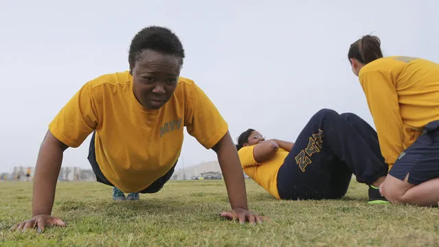 Petty Officer Lentoyi White does pushups while training with fellow Petty Officer Theresa White Monday, February 29, 2016, in Coronado, Calif. The pair are trying to lose weight and improve their fitness in order to pass the Navy fitness test and avert being discharged. (Photo by Lenny Ignelzi/AP Photo)