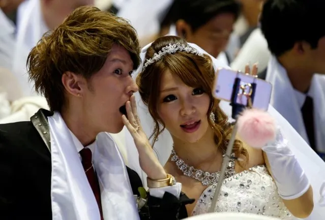 A couple takes their selfie in a mass wedding ceremony at the Cheong Shim Peace World Center in Gapyeong, South Korea, Saturday, February 20, 2016. (Photo by Lee Jin-man/AP Photo)