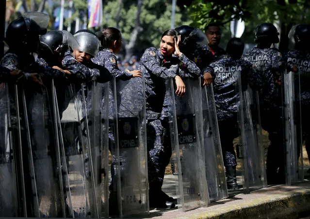 Police stand guard in anticipation of a march called by a coalition of opposition parties and civic groups who are petitioning lawmakers for a law of guarantees that will protect workers who have been victims of political retaliation and unjustified dismissals, in Caracas, Venezuela, Tuesday, March 19, 2019. (Photo by Fernando Llano/AP Photo)