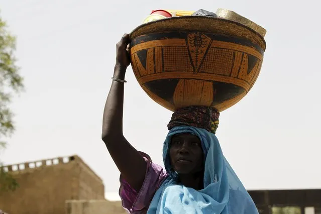 A milk maid carries a calabash filled with milk at a camp for internally displaced people in Maiduguri, Nigeria March 9, 2016. A Nigerian government push to strangle the Boko Haram insurgency has shut down the cattle trade that sustained the city of Maiduguri, leaving many residents with no livelihood, including many of the two million people displaced by the war. In recent months the army has taken back much of the territory lost to the jihadists during the five-year insurgency. (Photo by Afolabi Sotunde/Reuters)