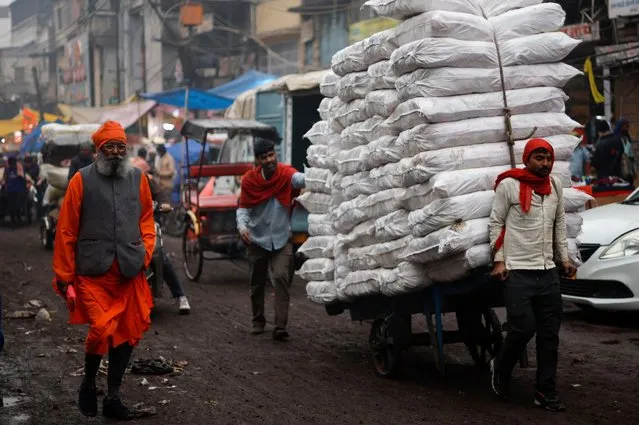 Labourers move a cart loaded with spice sacks at a wholesale market, a day before Indian Prime Minister Narendra Modi's government presents its final budget, ahead of the nation's general election, in the old quarters of Delhi, India, on January 31, 2024. (Photo by Adnan Abidi/Reuters)