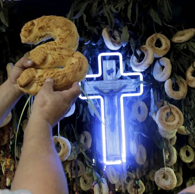 A traditional cheese and corn buns called a “chipa” in the shape of the number three is pictured as the Antar family decorates an altar in celebration of Kurusu Ara in Asuncion May 3, 2015. (Photo by Jorge Adorno/Reuters)