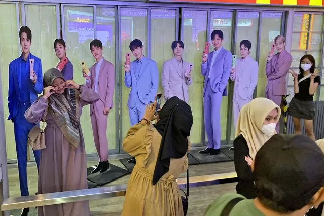 Fans take photos with cardboard cutouts of members of South Korean boy band Exo at a shopping mall in Jakarta, Indonesia, Sunday, February 4, 2024. As Indonesia votes this month to replace popular President Joko Widodo, all three candidates have all been aggressively seeking to win the votes of younger people, reaching out to them on the apps they use, through the K-pop music many love, and even video gaming events. (Photo by Dita Alangkara/AP Photo)