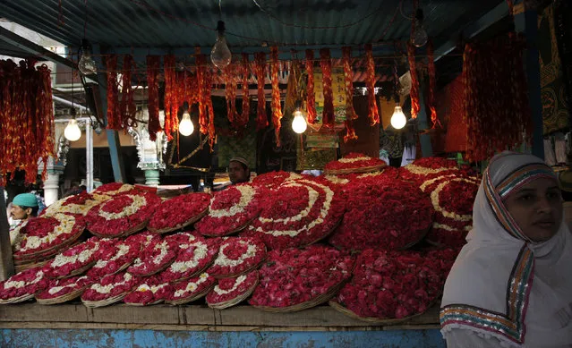 A Muslim devotee stands next to a stall selling flower petals and sacred threads inside the compound of the shrine of Sufi saint Khwaja Moinuddin Chishti ahead of Pakistan's President Asif Ali Zardari's visit in Ajmer, the desert Indian state of Rajasthan April 7, 2012. (Photo by B. Mathur/Reuters)