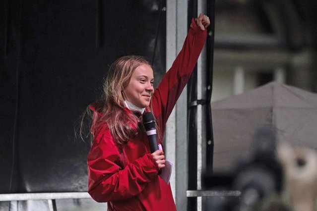 Swedish climate activist Greta Thunberg salutes after giving her speech on the stage of a demonstration in Glasgow, Scotland, Friday, November 5, 2021 which is the host city of the COP26 U.N. Climate Summit. (Photo by Jon Super/AP Photo)