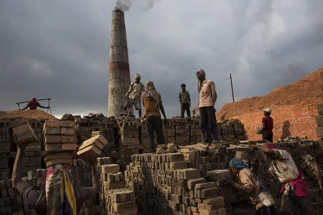 In this Wednesday, May 13, 2015 photo, Indian and Nepalese laborers work at a brick factory in Bhaktapur, Nepal. (Photo by Bernat Amangue/AP Photo)