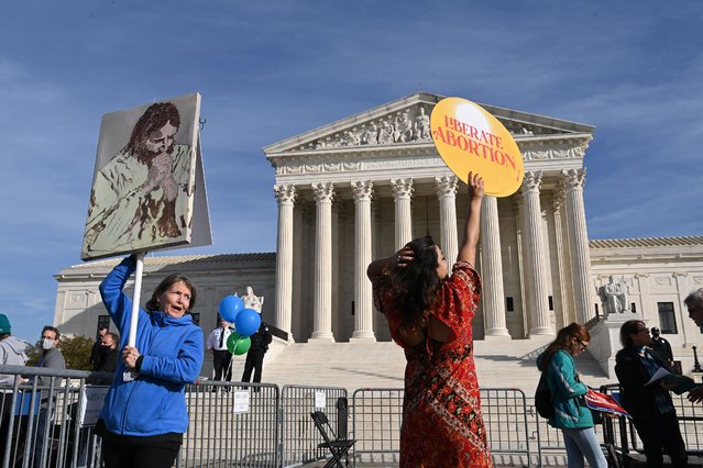 Barbara DuBrul of Long Island, NY, left, stands in the designated area for anti-abortion supporters as an abortion rights supporter, who did not want to give her name, dances nearby outside the Supreme Court of the United States as the court prepares to hear a case out of Mississippi that could challenge the law on abortions on Wednesday December 01, 2021 in Washington, DC. The case could overturn the landmark abortion case of Roe v. Wade. (Photo by Matt McClain/The Washington Post)