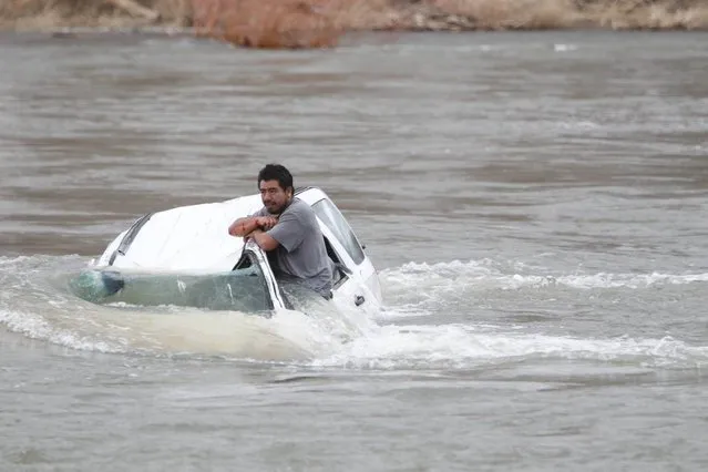 A man stranded in his car in the Yakima River in Wapato, Wash., on Sunday, March 16, 2014 in Wapato, Wash.  Yakima County emergency responders rescued the man Sunday evening.  A witness saw one man make it to shore, but another man was apparently trapped in the car as it filled with frigid water. The sheriff's swiftwater rescue boat arrived in time to pull him to safety. He was taken to a hospital to be treated for hypothermia and possible injuries from the accident. (Photo by Kaitlyn Bernauer/AP Photo/Yakima Herald-Republic)