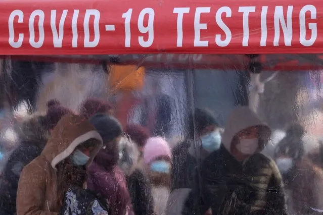 People queue to be tested for COVID-19 in Times Square, as the Omicron coronavirus variant continues to spread in Manhattan, New York City, U.S., December 20, 2021. (Photo by Andrew Kelly/Reuters)